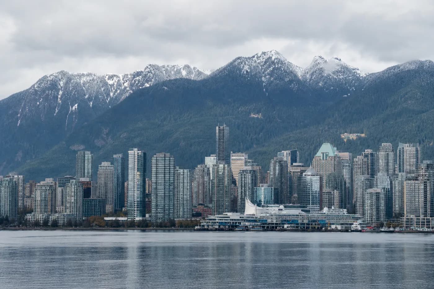 Downtown Vancouver skyline across Coal Harbour with the snow-capped North Shore mountains behind it, British Columbia