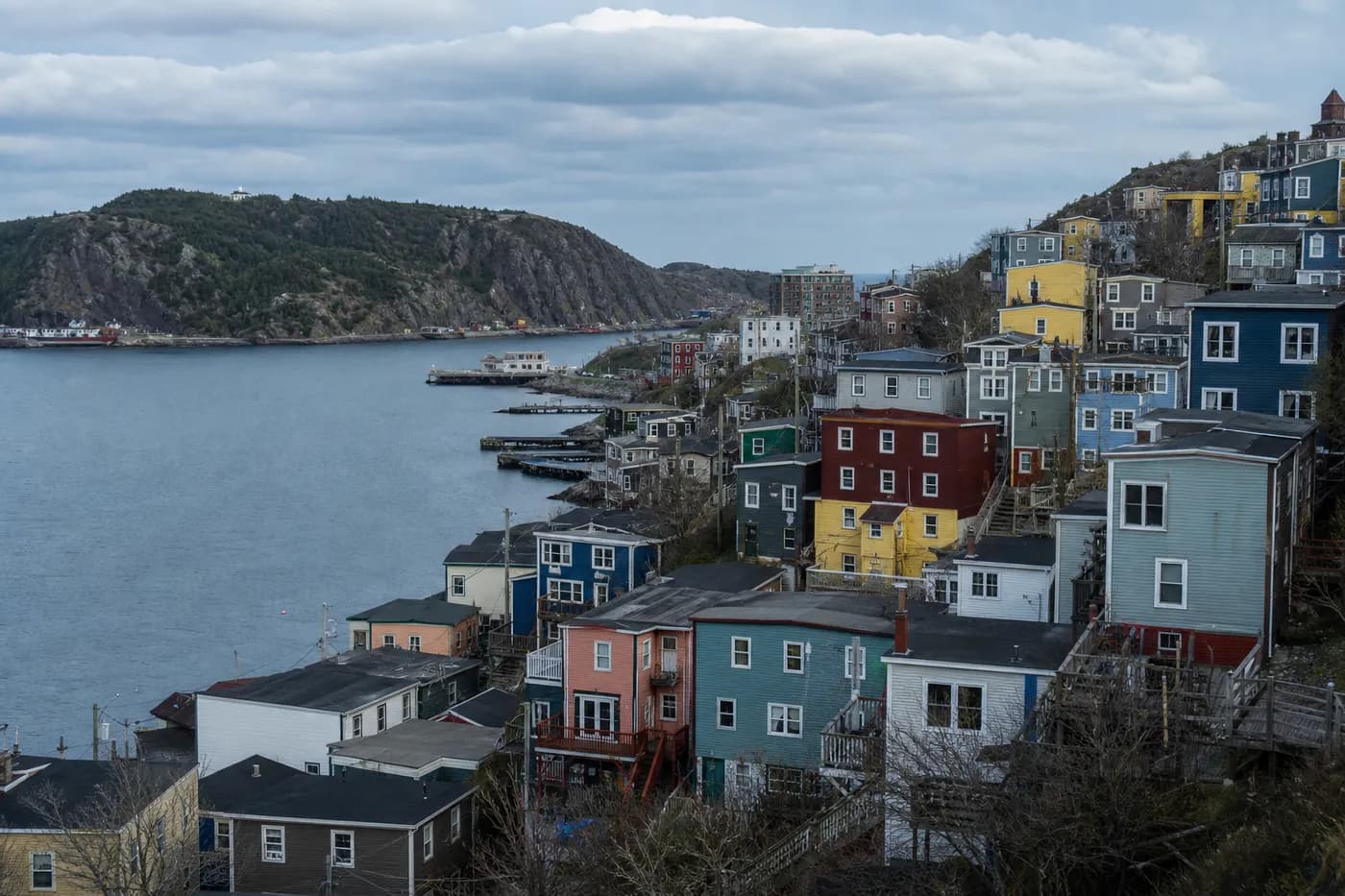 Steep hillside of tightly packed wooden row houses in heritage colours overlooking St John’s harbour, Newfoundland and Labrador